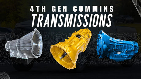 Three 4th Gen Cummins truck transmissions, metallic, yellow, and blue, on dark background.