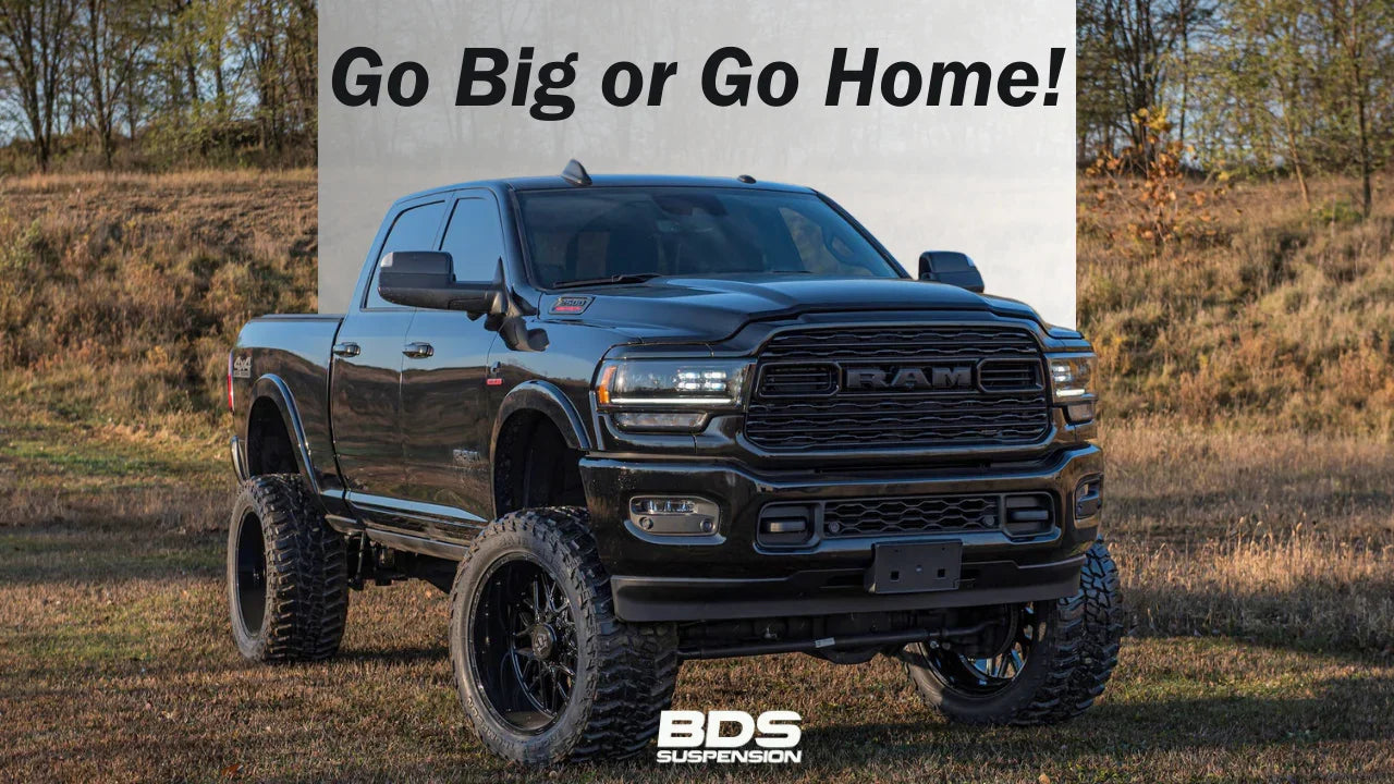 Lifted black RAM truck with BDS suspension on off-road terrain, large tires, outdoor setting
