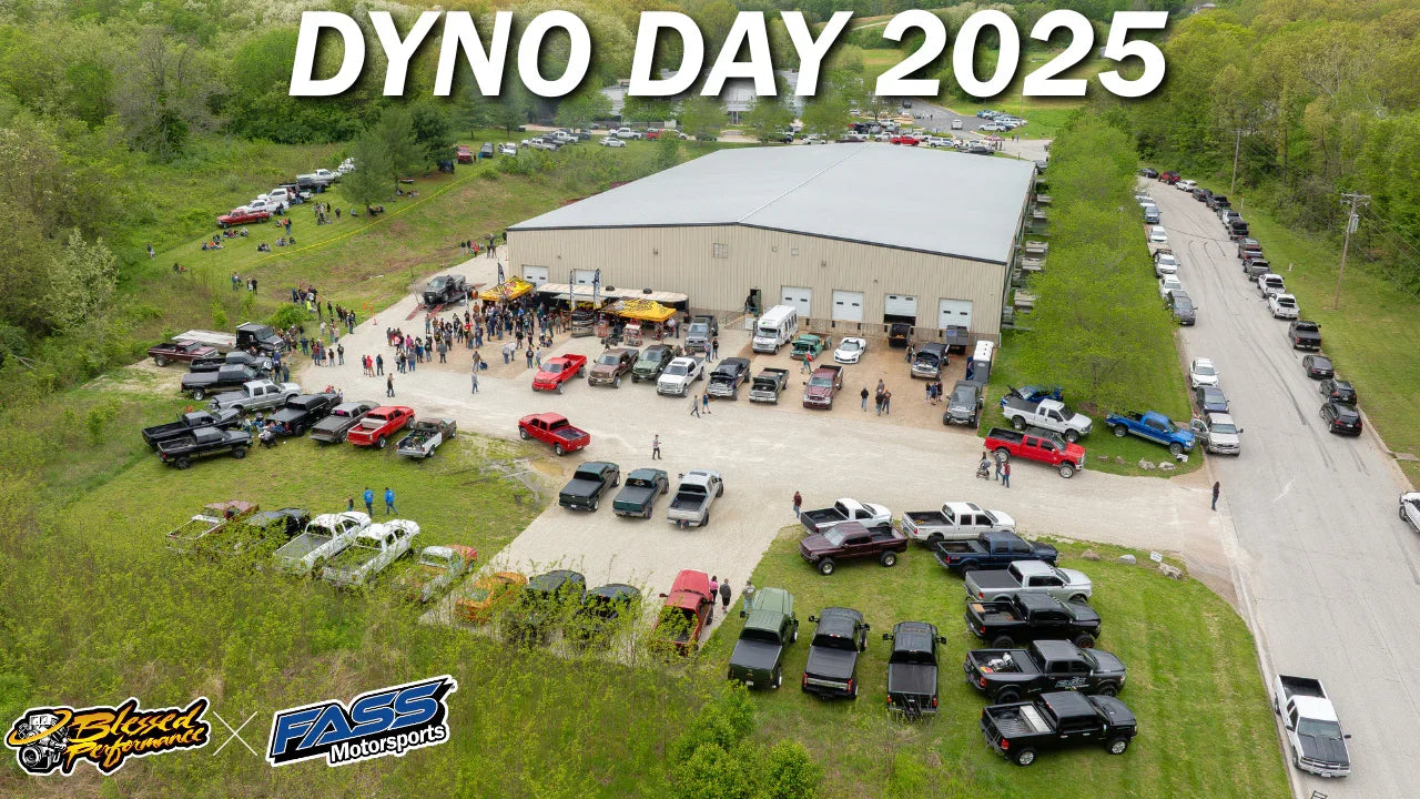 Aerial view of Dyno Day 2025 event with trucks, Jeeps, and SxS vehicles outside a large building.