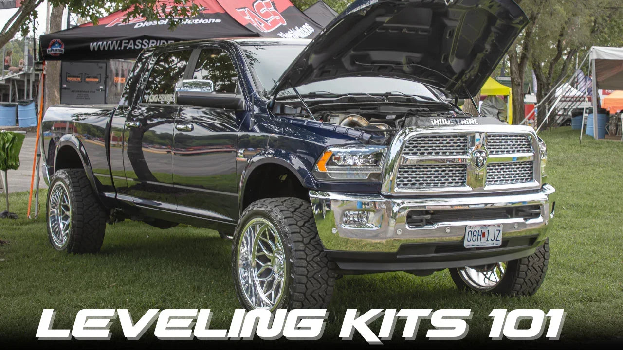 Lifted pickup truck with open hood at outdoor event, showcasing leveling kit upgrade