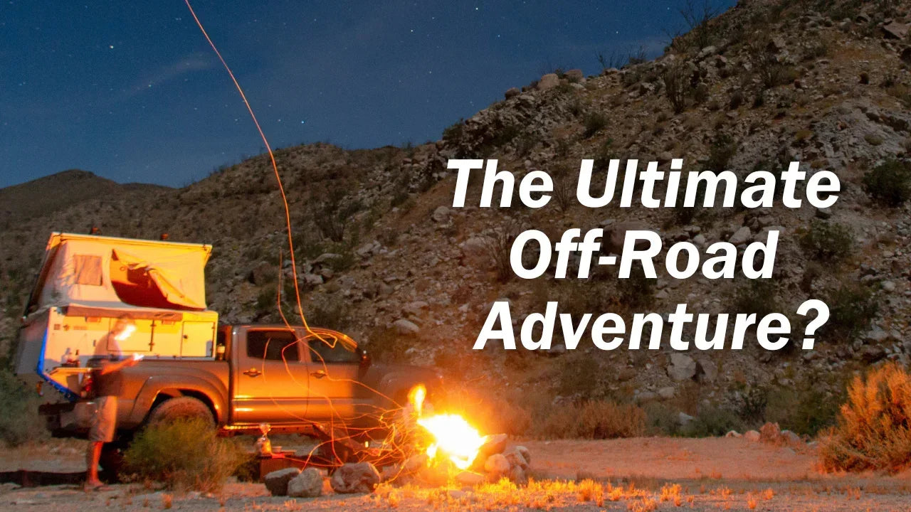 Truck with rooftop tent camping by campfire at night in remote off-road desert setting