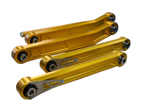 A set of yellow billet replacement rear suspension parts for RAM TRX vehicles, displayed on a workbench.